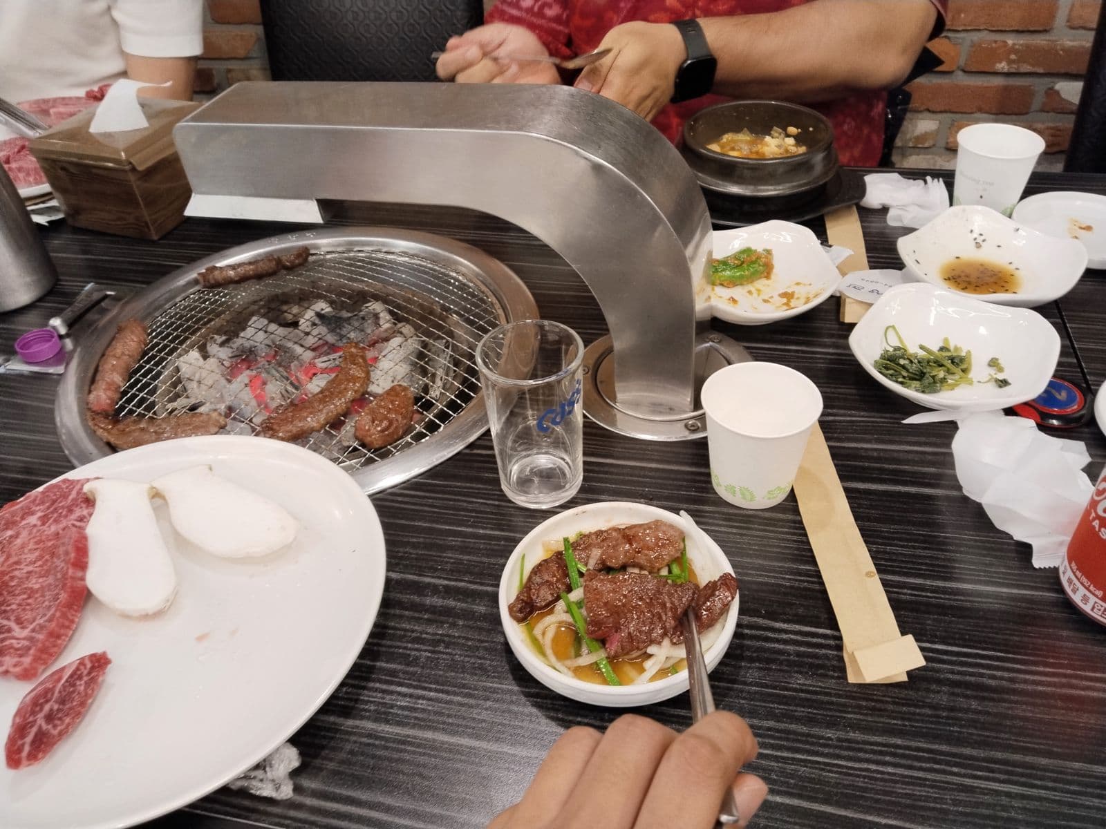 Beef grilling over charcoal at the table