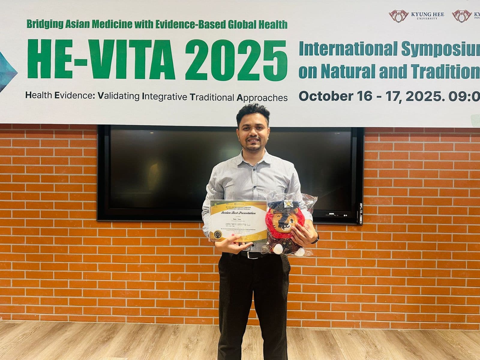 Holding my Session Best Presentation certificate and the Kyung Hee University lion mascot